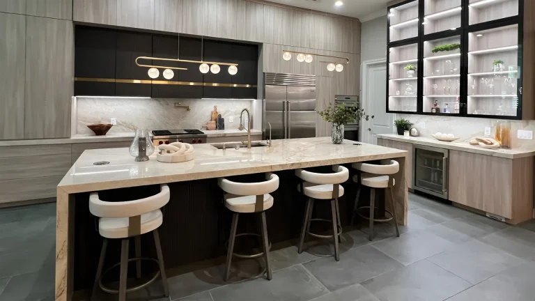 Modern luxury kitchen with white quartz island, wood grain cabinets, black upper cabinets, marble backsplash and white bar stools in Fort Lauderdale home